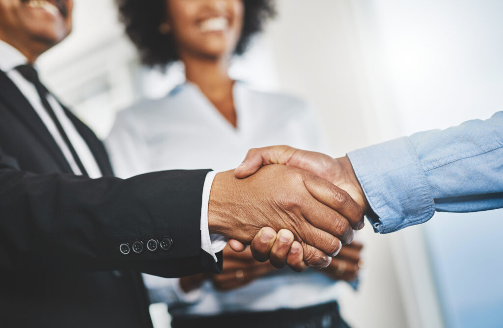 Two business professionals shaking hands after closing a deal.