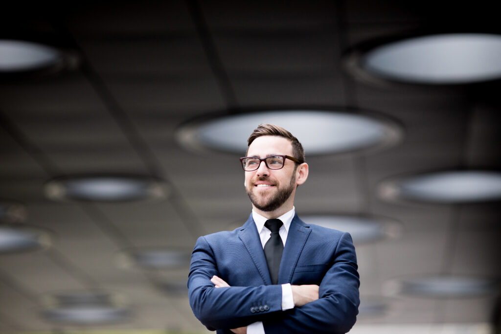 A business leader standing confidently in a corporate setting.