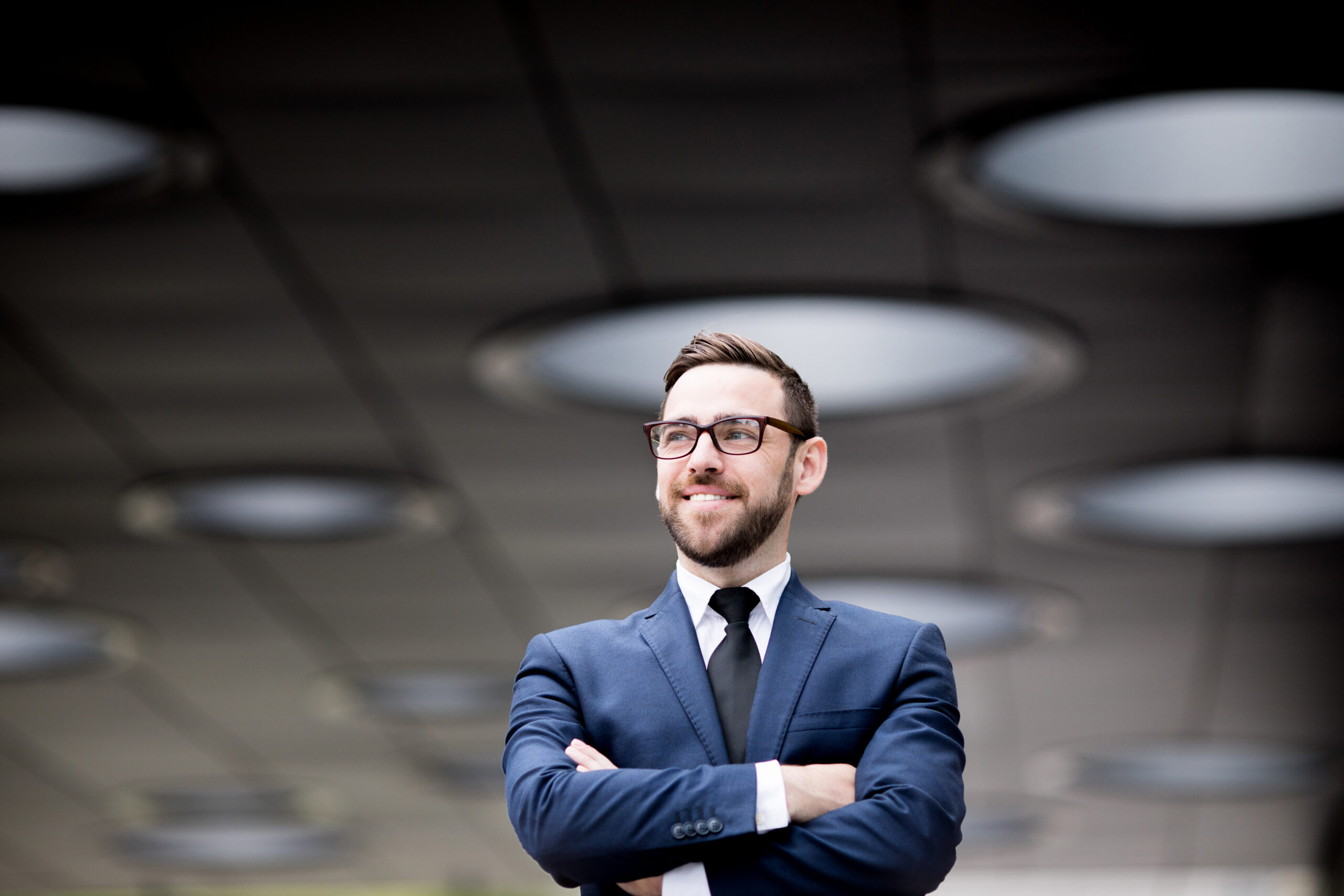 A business leader standing confidently in a corporate setting.